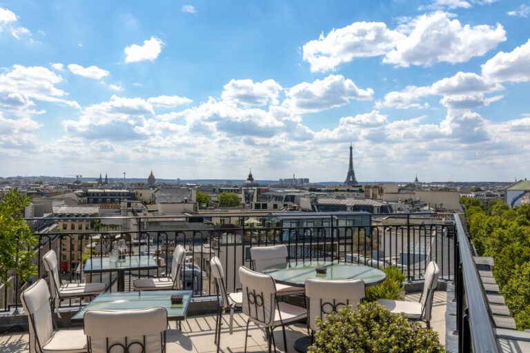 view from a Paris rooftop at sunset with cocktails and skyline in the background
